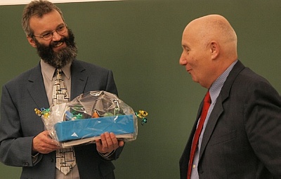Dr. Vinzenz Brendler überreicht das Geburtstagsgeschenk des HZDR-Instituts für Ressourcenökologie an Prof. Dr. Gert Bernhard
