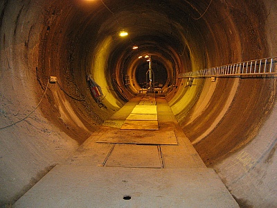 Der Tunnel im schwedischen Versuchs-Endlager Äspö mit rötlich gefärbten Granitwänden bohrt sich rund 700 Meter in die Tiefe. An seinen Wänden wachsen Biofilme in und um wasserhaltige Klüfte.