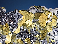 Kristallaggregat von Kupferkies, Bleiglanz, Zinkblende und Kalkspat. Eine solche Vergesellschaftung enthält u.a. Indium, Germanium und Silber.