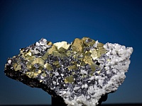 Kristallaggregat von Kupferkies, Bleiglanz, Zinkblende und Kalkspat; enthält u.a. Indium, Germanium und Silber.