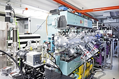 Foto: The free-electron laser (FEL) of the French SOLEIL partners converts the electron pulses generated by the high-power laser DRACO at HZDR into light flashes. In the foreground, the beamline framed by a light-blue magnet arrangement - the undulator; in the background, the metallic beam chamber for the DRACO laser. ©Copyright: HZDR/Sylvio Dittrich